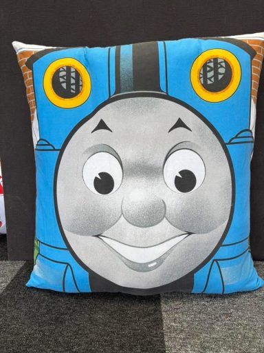 Square cushion featuring a smiling face of a cartoon train character with blue accents.