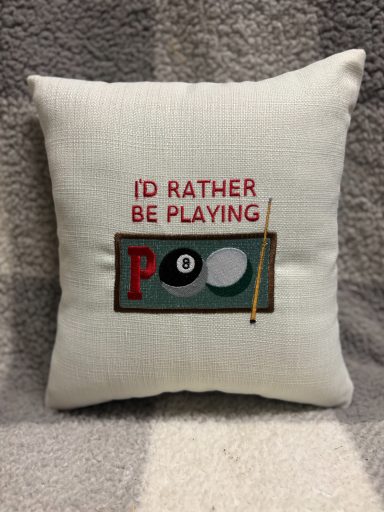 A cushion with the text "I'd rather be playing pool" and a cue and balls graphic.