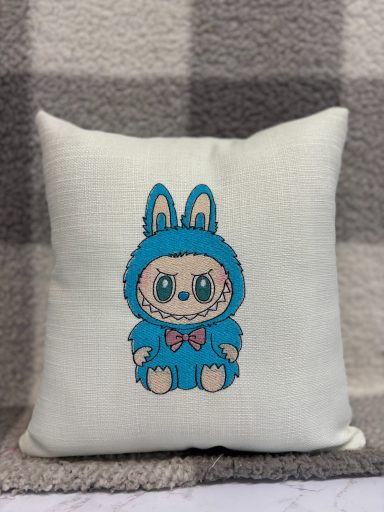 Blue decorative cushion featuring a cartoonish bunny character in a hoodie.