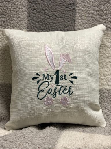 Decorative cushion featuring "My 1st Easter" and a bunny motif.