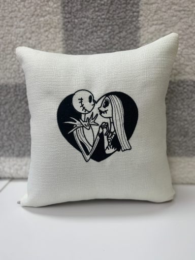 A decorative cushion featuring Jack Skellington and Sally from The Nightmare Before Christmas.