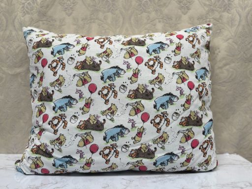 Pillow featuring a playful design of cartoon animals and objects in vibrant colours.