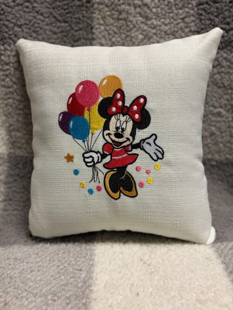 Cushion featuring Minnie Mouse with balloons and a cheerful pose.