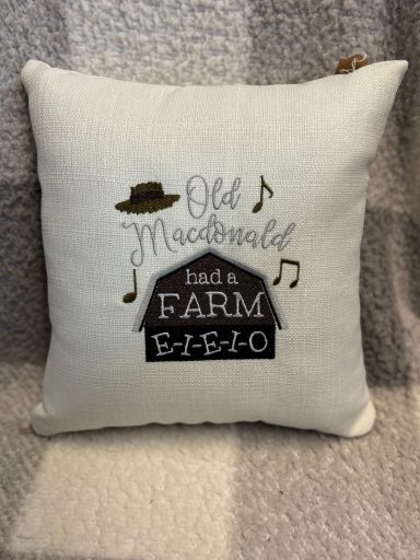 Cushion featuring the text "Old MacDonald had a farm" and musical notes.