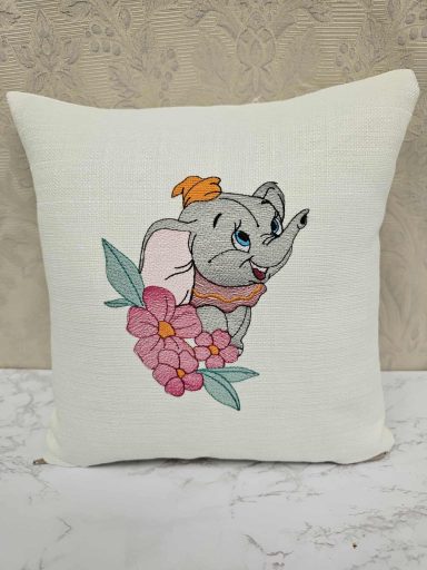 Cartoon elephant with a hat surrounded by flowers on a cushion.