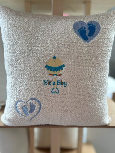 A soft decorative cushion with baby-themed designs and the word "hearty."
