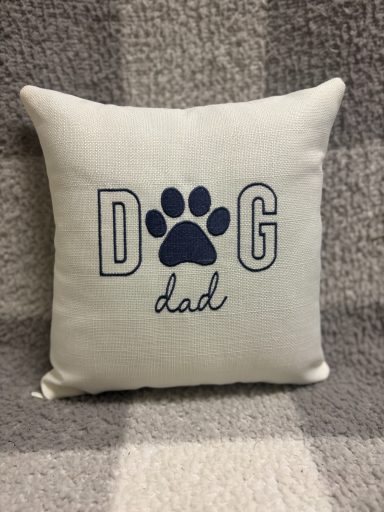 Cushion with "DOG dad" text and a paw print design.