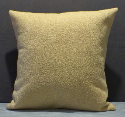Plain yellow cushion with a textured surface against a dark background.