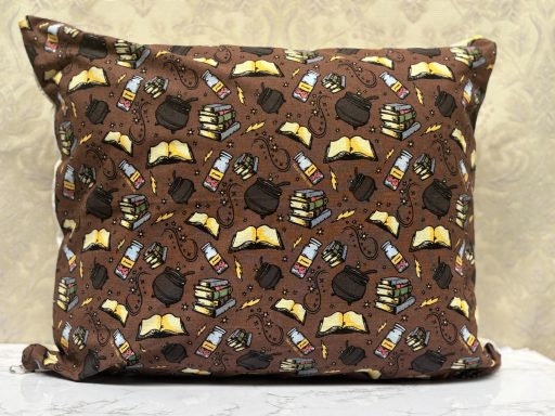 Brown pillow with a pattern of books, quills, and owls.