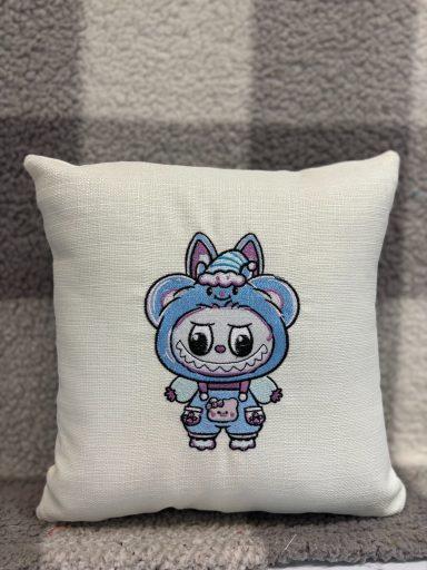 Cuddly cartoon character in a blue outfit with ears, printed on a decorative cushion.