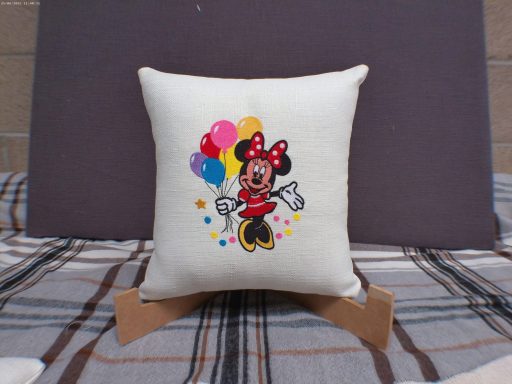 Cream cushion featuring Minnie Mouse holding colourful balloons.