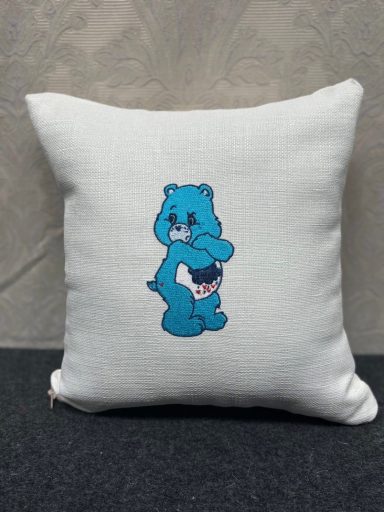 Cushion featuring a blue bear character with a playful pose.