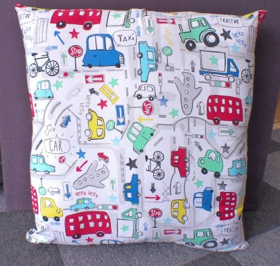 Colourful cushion covered in playful traffic and vehicle patterns.