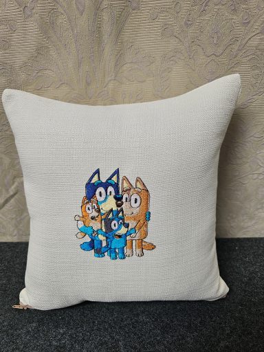 Cushion featuring a cartoon character surrounded by two playful animals.