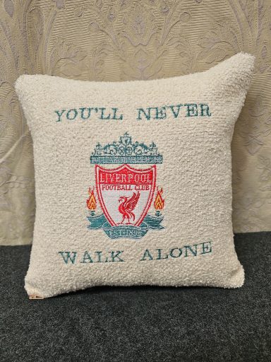 White cushion with the Liverpool FC crest and the text "YOU'LL NEVER WALK ALONE."