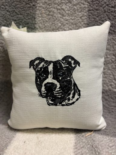 Decorative cushion featuring an embroidered portrait of a dog, likely a pit bull.