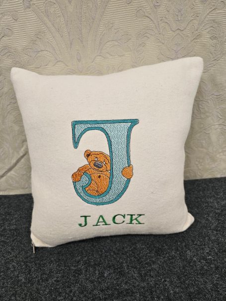 Square cushion featuring the letter "J" and the name "JACK," with a cartoon animal.