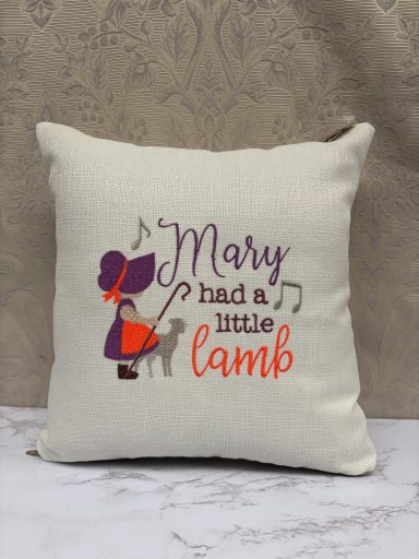 Cushion with the text "Mary had a little lamb" and a girl with a lamb illustration.