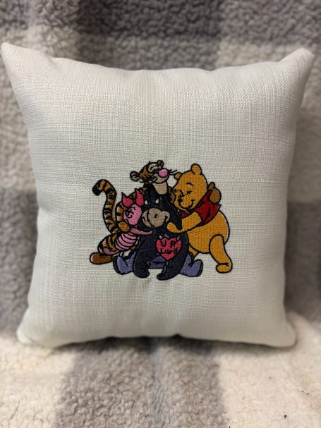Cushion featuring Winnie the Pooh and friends in a playful group pose.