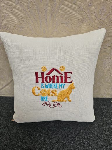 Cushion with the text "Home is where my cats are" and a yellow cat silhouette.