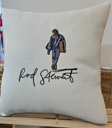 Cushion featuring a figure in a jacket and the name "Rod Stewart" in an artistic font.