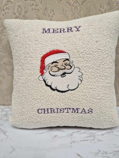 Cream cushion with a cartoon Santa and the text "Merry Christmas" beneath him.