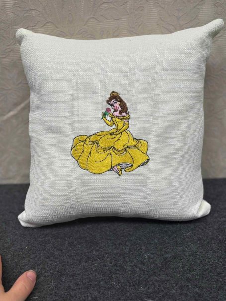 A cushion featuring a decorated illustration of a princess in a yellow gown.