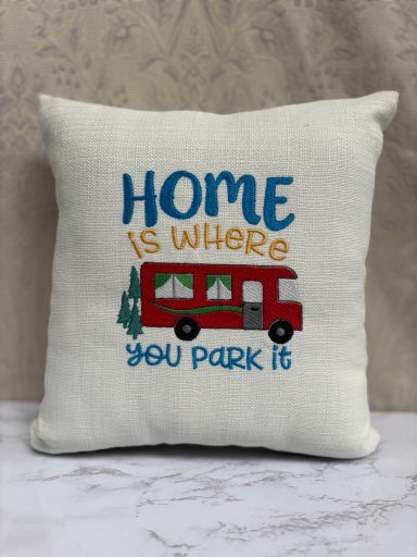 Cushion with the text "Home is where you park it" and a graphic of a red camper van.