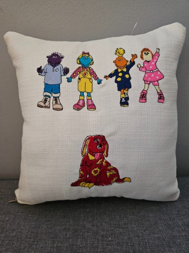 Cushion featuring four cartoon characters and a large dog.