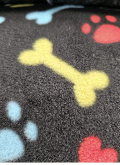 Black fabric with colourful paw prints and a yellow bone pattern.