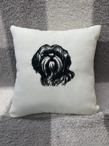 A decorative cushion featuring a black and white illustration of a dog.