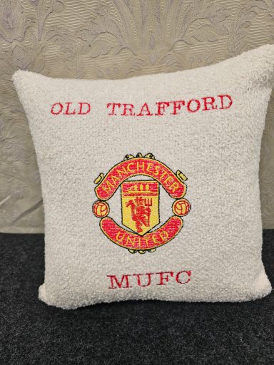 White cushion with red lettering: "Old Trafford" and "Manchester United MUFC" logo.