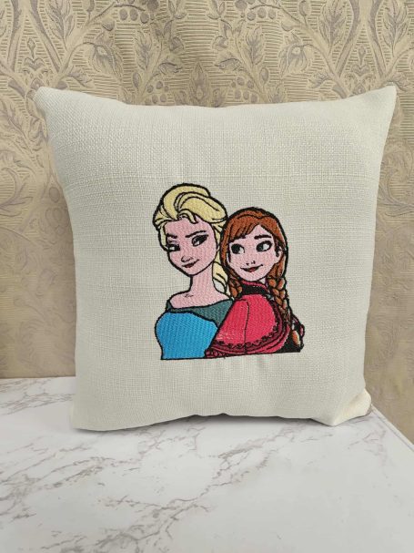 Cushion featuring illustrated characters Elsa and Anna from Disney's Frozen.