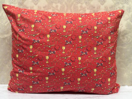 Red decorative pillow with a floral and balloon pattern.