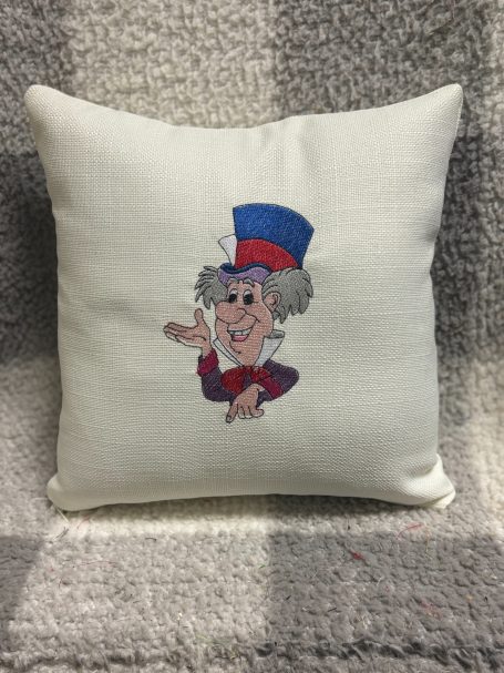 A decorative cushion featuring a cartoon character in a blue and red hat.