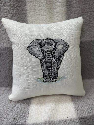 Decorative cushion featuring a grey elephant illustration on a soft fabric background.