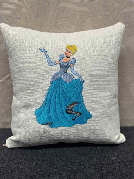 Cinderella in a blue dress, with a flowing skirt, on a decorative cushion.