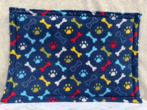 Blue pet bed featuring colourful bone and paw print patterns.