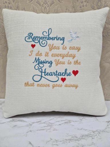 Decorative cushion with embroidered text about love and remembrance.