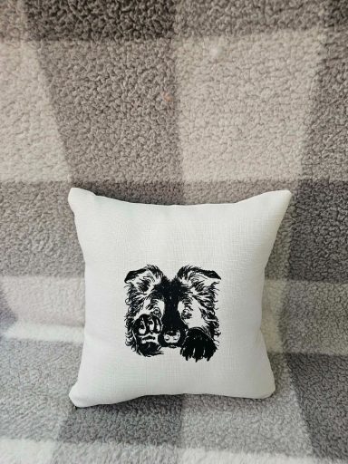 White cushion with a black graphic of two lion faces.
