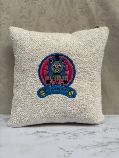 Cream-coloured cushion featuring a cartoon character design in vibrant colours.