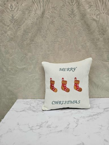 Decorative cushion featuring three red Christmas stockings and the text "Merry Christmas."