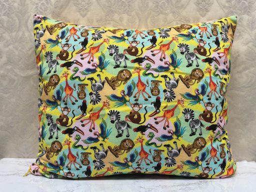Cushion featuring a vibrant, multicoloured animal pattern on a pastel background.
