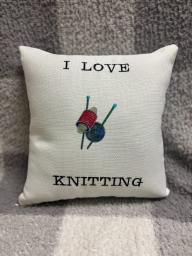 Square cushion with the text "I Love Knitting" and graphic of yarn and knitting needles.