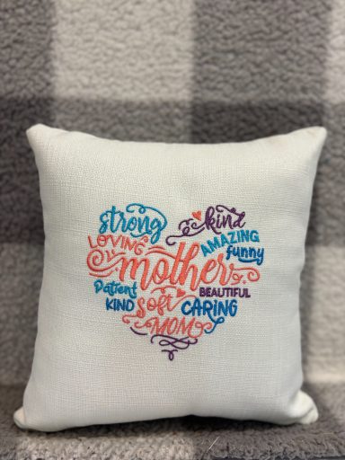 Cushion with a heart-shaped design made of words celebrating mothers.