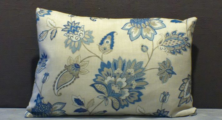 Decorative cushion featuring blue floral patterns on a light background.