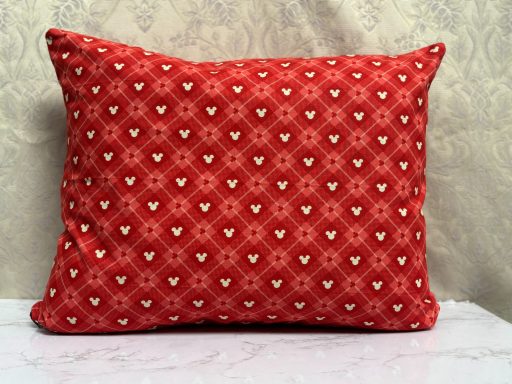 Red decorative cushion with a patterned design featuring small hearts.