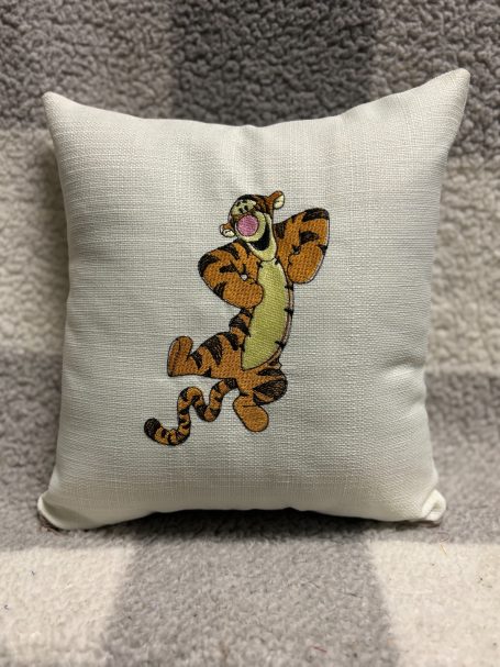 A cushion featuring an animated tiger character with a playful expression.