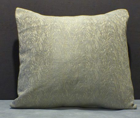 A plain, rectangular cushion with a textured, light-coloured surface.