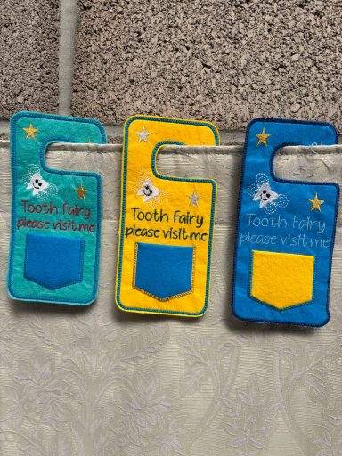 Three brightly coloured fabric pockets labelled "Tooth Fairy" in blue and yellow.